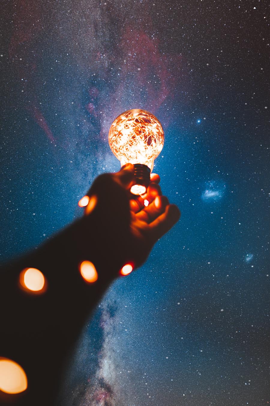 person-holding-light-bulb-with-string-lights-inside-1830252_900